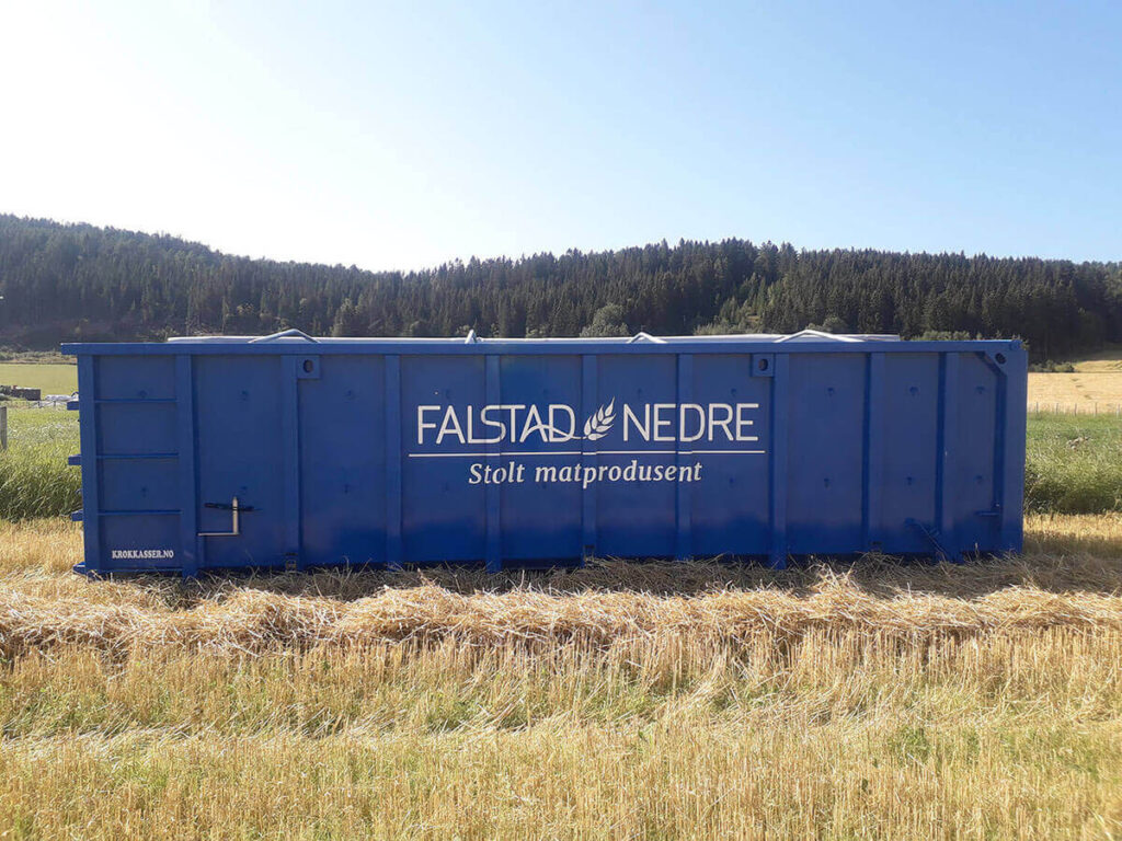 Blå container dekorert med logo for Falstad Nedre.