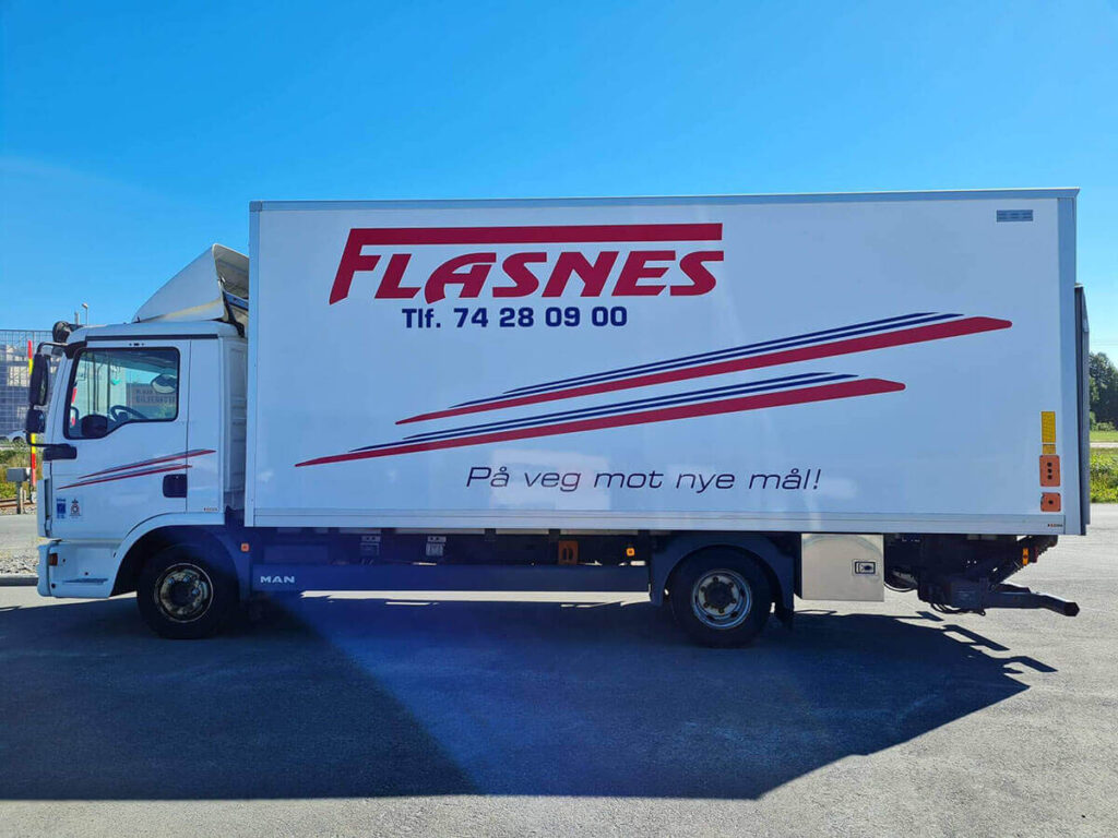 Hvit lastebil med logo for Flasnes.