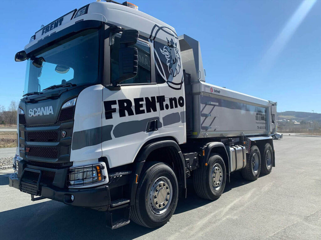 Svart og hvit Scania med logo for Frent.