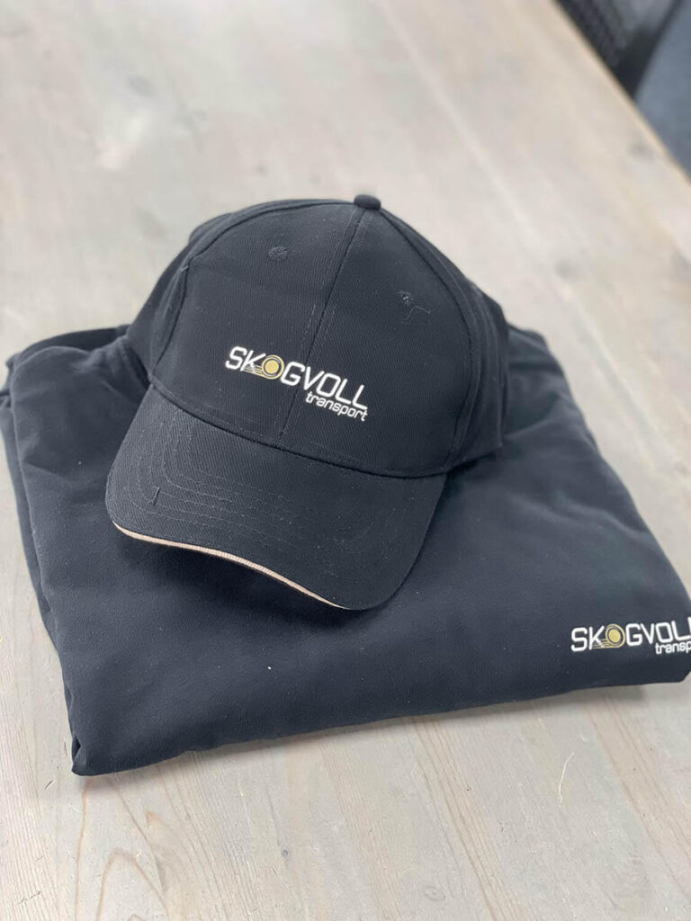 Caps og genser med logo for Skogvoll Transport.