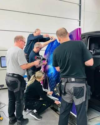 Fem montører i gang med helfoliering av lastebil.