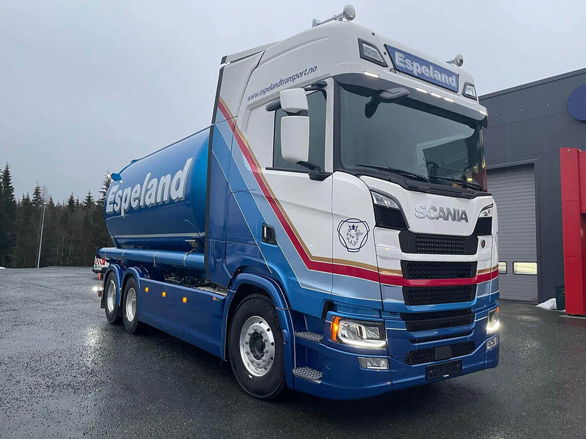 Hvit Scania lastebil med logo og dekor for Espeland.